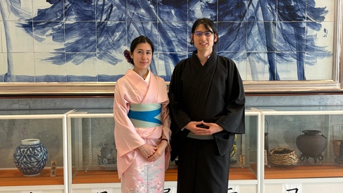 Dr. Ryuhei Sato  and Dr. Maélie Caussé wearing traditional Japanese clothing stand in front of a museum-style display.